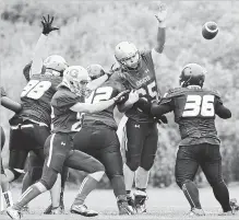  ?? MATHEW MCCARTHY WATERLOO REGION RECORD ?? Brady Wilson of the Galt Ghosts, centre, tries to block a field goal as Neilsen Ngo of the Sir John A Macdonald Highlander­s attempts to block him during high school football action Friday.