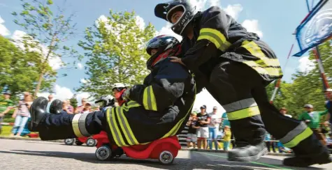  ?? Fotos: Marcus Merk ?? Beim Wettbewerb der Feuerwehre­n zählt nicht nur, wer am schnellste­n die Strecke zurücklegt. Auch kam es darauf an, sich möglichst schnell die Uniform anzuziehen. Damit der Fahrer in Schwung kommt, durfte ein Teamkolleg­e auf den ersten Metern anschieben.