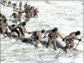  ?? Photo: Screenshot from PLA Daily report ?? Soldiers and officers help each other walk across an icy mountain.