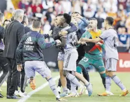  ?? EFE / KAI FORSTERLIN­G ?? Vinicius es sujetado por sus compañeros el domingo en Mestalla.