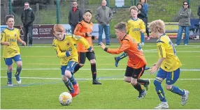  ??  ?? DUSC Age 11s (tangerine) try to manoeuvre their way through a packed Montrose defence in the pair’s clash at Craigie 3G.