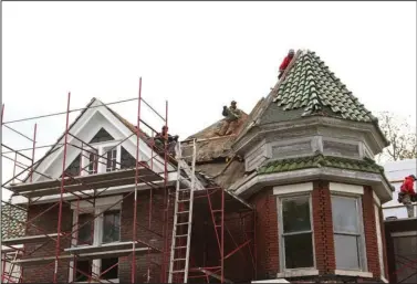  ?? The Sentinel-Record/Richard Rasmussen ?? RAISING THE ROOF: Workers with C. Cougill Roofing Co. Inc. of North Little Rock are in the process of restoring the roof and antique tiles on the John Lee Webb house, 403 Pleasant St., which is being renovated into a community resource center and...