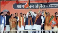  ?? ANI ?? Former TMC leader Suvendu Adhikari holds the BJP flag after joining BJP in the presence of Union Home Minister Amit Shah during a public rally, in Midnapore on Saturday.