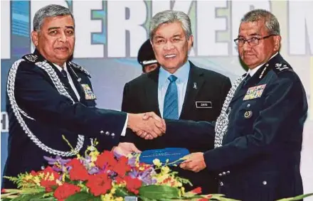  ?? PIC BY SAIRIEN NAFIS ?? Deputy Prime Minister Datuk Seri Dr Ahmad Zahid Hamidi witnessing the handover of duties of the inspector-general of police between Datuk Seri Mohamad Fuzi Harun (right) and Tan Sri Khalid Abu Bakar at the Police Training Centre in Kuala Lumpur...