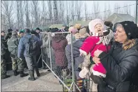  ?? AP PHOTO ?? A baby girl cries in her mother’s arms as they stand in queue to get humanitari­an aid at the humanitari­an aid center in Avdiivka, eastern Ukraine, Friday.