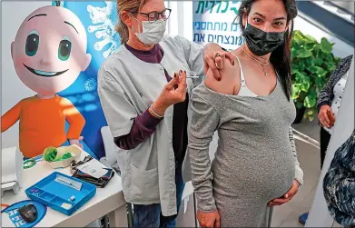  ??  ?? seCURItY: A health worker gives a pregnant woman a dose of the Pfizer-BionNtech vaccine in Tel Aviv