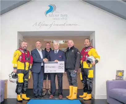  ??  ?? Representa­tives from the Silver Bay Holiday Village on Anglesey handing over a cheque to the Trearddur Bay RNLI