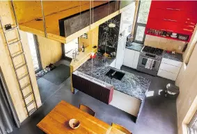  ??  ?? The soapstone kitchen surfaces and concrete floors in the chalet hold both heat and cold.