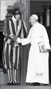  ?? ASSOCIATED PRESS ?? IN THIS OCT. 2015 FILE PHOTO, Pope Francis shakes hands with a Vatican Swiss guard as he leaves after a morning session of the Synod of bishops at the Vatican.