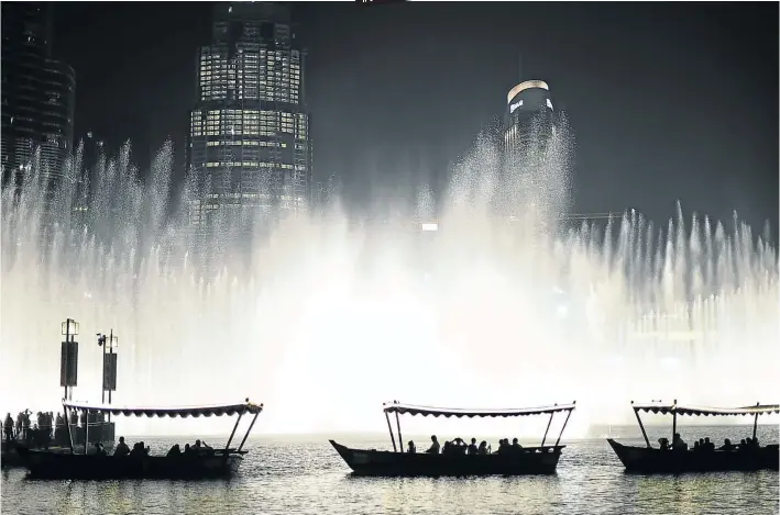  ?? Picture: Tom Dulat/Getty Images ?? DANCE ON THE WATER Spectators watch the Dubai fountain on the man-made Burj Khalifa Lake in downtown Dubai.