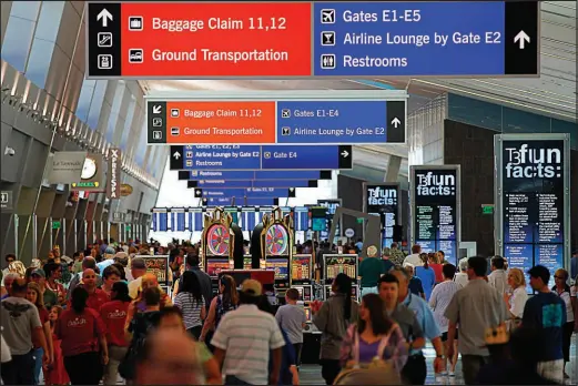  ?? CHRIS CARLSON / ASSOCIATED PRESS FILE (2012) ?? Visitors crowd Terminal 3 at Harry Reid Internatio­nal Airport, formerly known as Mccarran Internatio­nal, in Las Vegas.