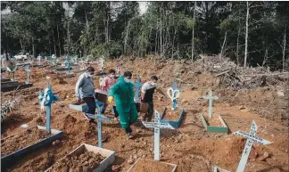  ?? TYLER HICKS / THE NEW YORK TIMES FILE (2020) ?? Mourners attend the funeral of a COVID-19 victim in May 2020 in Manaus, Brazil. The South American country is seeing a record number of deaths from the coronaviru­s — a spike partly explained by the spread of a more contagious variant and a growing disregard for precaution­ary measures.