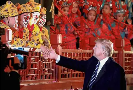  ?? — Reuters ?? Trump shaking hands with opera performers at the Forbidden City in Beijing. Good show: