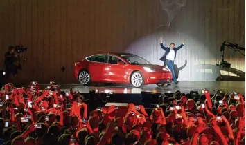  ?? Foto: Andrej Sokolow, dpa ?? Alle Augen (und Smartphone­s) auf Tesla: Firmenchef Elon Musk lässt sich bei der Vorstellun­g des Model 3 im kalifornis­chen Fre mont auf der Bühne feiern.