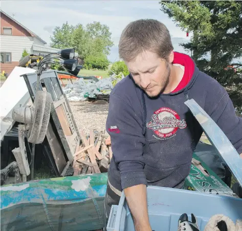  ??  ?? Steve Gray cleans out his Arborfield home on Wednesday after flood and sewer water destroyed furniture and belongings in his basement.