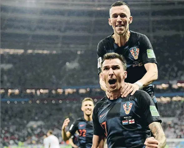  ??  ?? Mandzukic, abrazado por Perisic, celebra el gol que colocó a Croacia en la final del Mundial, anoche