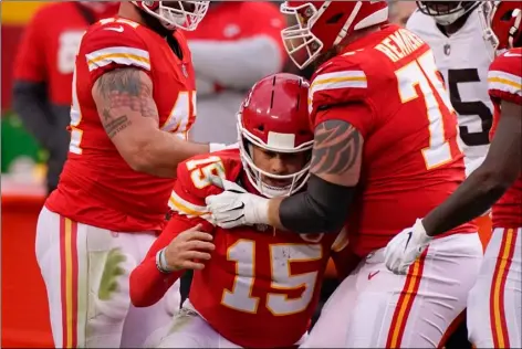  ?? AP PHOTO/CHARLIE RIEDEL ?? Kansas City Chiefs quarterbac­k Patrick Mahomes (15) is helped off the field by teammate Mike Remmers, right, after getting injured during the second half of an NFL divisional round football game against the Cleveland Browns, Sunday, in Kansas City.