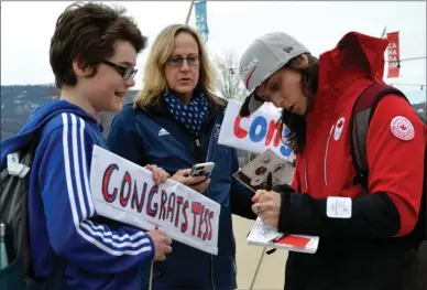  ?? ANDREA PEACOCK/The Daily Courier ?? PeyongChan­g 2018 gold medalist Kelsey Serwa signs her autograph for fans Manoah Kleemaier, left, and Cathie Pavlik. Below, Olympian Tess Critchlow speaks at Stuart Park in Kelowna Wednesday afternoon.