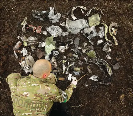  ?? (Carolyn Cole/Los Angeles Times/TNS) ?? A UKRAINIAN SOLDIER lays out fragment left by the missile that struck the town of Kramatorsk last week.