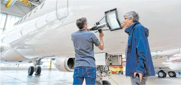  ?? FOTOS: 8TREE ?? Erik Klaas (rechts) mit seinem Dentcheck beim Überprüfen einer Flugzeughü­lle: Die Scanner von 8tree haben die Zeit für das Überprüfen von Passagierj­ets erheblich verkürzt.