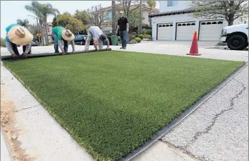  ?? Luis Sinco
Los Angeles Times ?? WORKERS roll out artificial grass for installati­on at a home in Pacific Palisades. Each dollar invested in turf rebates is expected to save 350 gallons of water over a 10-year period, the controller’s office said.