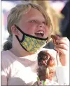  ??  ?? Averie Pannell, 9, of Santa Fe Springs digs into a baconwrapp­ed turkey leg on the opening day of the Bite-Sized Fair at Fairplex in Pomona on Friday.