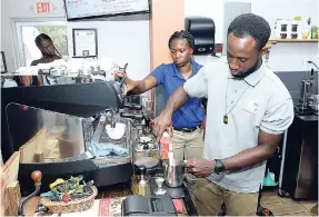  ??  ?? Deaf Can! barista Fabian Jackson adds milk to the machine to get steamed and then added to make a latté.