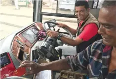  ?? Photo: Ronald Kumar ?? Sat Dewan (right) uses his e-Transport card to pay for his bus fare on September 28, 2017 as bus driver Rajesh Kumar looks on.