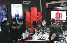  ?? WANG JING / CHINA DAILY ?? Consumers pick cosmetics at a mall in Wuhan, Hubei province, on March 30.