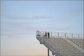  ??  ?? Dusk settles as two spectators watch a football game between El Modena and El Dorado in Orange, Calif. (AP/Jae C. Hong)