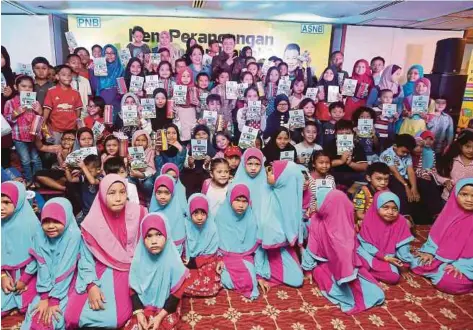  ?? [FOTO SALHANI IBRAHIM/BH] ?? Aznil ketika mengacarak­an penutup Kem Perancanga­n Kewangan ASNB bersama 150 kanak-kanak di Menara PNB, Kuala Lumpur, semalam.