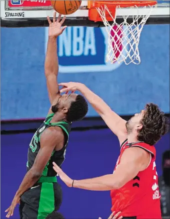  ?? MARK J. TERRILL/AP PHOTO ?? Kemba Walker banks in a reverse layup over Toronto’s Marc Gasol, right, during the first half of Game 5 of the NBA Eastern Conference semifinals on Monday night in Lake Buena Vista, Fla. The Celtics won 111-89.