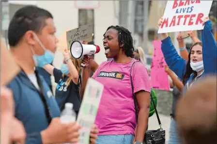  ?? SEAN D. ELLIOT (ABOVE) AND TAYLOR HARTZ (TOP)/THE DAY ?? Above, Alexis Thornton, of New London, leads a subset of Black Lives Matter protesters to block traffic in Liberty Pole Square in Mystic on Friday. Top, Maureen Meehan, 65, and her daughter and Kerry Meehan, 36, both of Mystic, protest in Mystic on Friday,