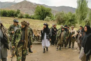  ?? KIANA HAYERI/THE NEW YORK TIMES ?? Mawlawi Mahdi Mujahid, a former Shiite commander within the mostly Sunni Taliban who renounced the Taliban government and seized control of a district in northern Afghanista­n, is seen at center in white on June 21.