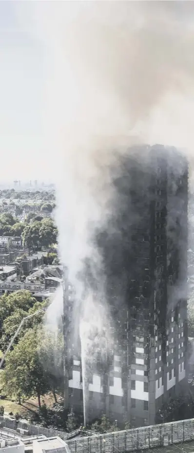  ??  ?? 0 Smoke billows from the tower block as firefighte­rs attempt to get the blaze under control while