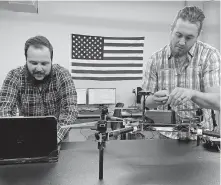  ??  ?? Berry Aviation intern Thomas Blehm and engineer Aron Felder integrate a drone for a defense customer at Berry Aviation's Unmanned Aerial Systems shop in Stillwater. Both are Oklahoma State University aerospace graduates. [PHOTO PROVIDED]