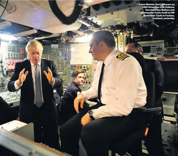  ??  ?? > Prime Minister Boris Johnson on HMS Victorious with Defence Secretary Ben Wallace and Commander Justin Codd at HM Naval Base Clyde in Faslane, Scotland, yesterday