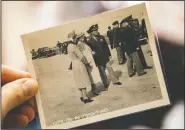  ?? (Lancaster LNP/Ty Lohr) ?? Adams holds a photo of Queen Elizabeth II (left) at his home. Adams was stationed at a base in England, shooting photograph­s of notables and royalty. He photograph­ed Elizabeth, the Queen Mother, one afternoon as she inspected the base with her then-teenaged daughter, the future Queen Elizabeth II.