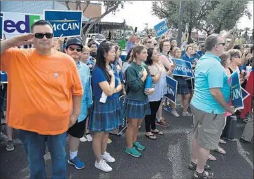  ?? Robyn Beck AFP/Getty Images ?? MOURNERS watch as a motorcade escorting Sen. John McCain’s casket passes by in Phoenix on Thursday.