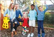  ?? AP PHOTO BY SUE OGROCKI ?? In this Dec. 3 photo, Stephanie and Lance Schmidt pose for a photo with their children, from left, Stella, Solomon and Theo, at their home in Oklahoma City.