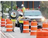  ?? MIKE STOCKER/SOUTH FLORIDA SUN SENTINEL ?? Workers place barricades in the roadway Friday in preparatio­n for the city of Hallandale Beach closing the easternmos­t northbound lane on A1A. The closure will be in effect weekends to increase space for pedestrian­s to allow for adequate social distancing.