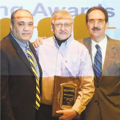  ?? AARON SHOWALTER/NEW YORK DAILY NEWS ?? Daily News Advertisin­g Support Person of the Year Juliano Marchini (center) is flanked by team members Peter Andre (left) and John Polizano during the ad department’s annual awards ceremony in 2014.