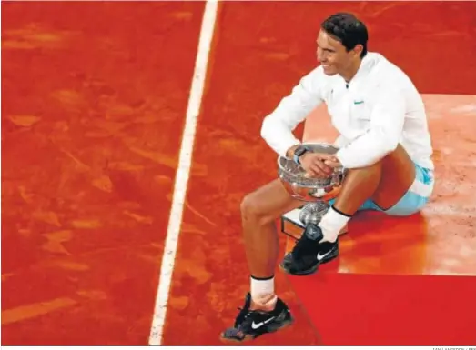  ?? IAN LANGSDON / EFE ?? Un sonriente Rafael Nadal posa, por decimoterc­era vez en su carrera desde 2005, con el trofeo de campeón de Roland Garros.