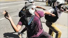  ?? RONALDO SCHEMIDT/GETTY-AFP ?? An opposition activist throws a Molotov cocktail during a protest Saturday in Caracas, the Venezuelan capital.