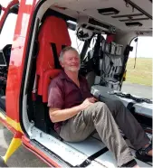  ??  ?? Bruce Goodwin spends a few emotional moments in the helicopter seat on which he sat after being pulled from the sea, during a visit to the Auckland Rescue Helicopter Trust base to thank his rescuers