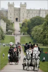  ?? ALASTAIR GRANT — THE ASSOCIATED PRESS ?? Horse-drawn carriages make their way down the Long Walk from Windsor Castle in Windsor, England, Friday. All roads seem to lead to Windsor Castle, a magnificen­t fortress perched high on a hill topped by the royal standard when the queen is in...