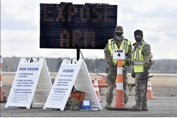  ?? AP file photo ?? Connecticu­t National Guard members wait to check in vehicles for Connecticu­t's largest COVID-19 Vaccinatio­n Drive-Thru Clinic in East Hartford, Conn., on Monday. The push to inoculate Americans against the coronaviru­s is hitting a roadblock: A number of states are reporting they are running out of vaccine, and tens of thousands of people who managed to get appointmen­ts for a first dose are seeing them canceled.