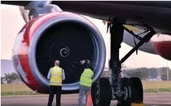  ??  ?? Officials inspect an engine of the AirAsia X aircraft after the incident.