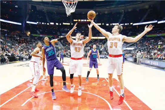  ??  ?? Atlanta Hawks guard Mike Dunleavy (34) grabs a rebound past forward Kris Humphries (43) and Charlotte Hornets forward Christian Wood (35) in the second half at Philips Arena on Tuesday night. (USA TODAY Sports)
