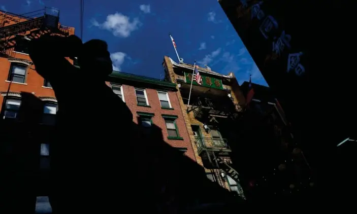  ?? Photograph: Shannon Stapleton/Reuters ?? A man wearing a protective face mask in Manhattan. Although new cases and deaths have declined across much of the US, there have still been surges in some states, such as Alaska.